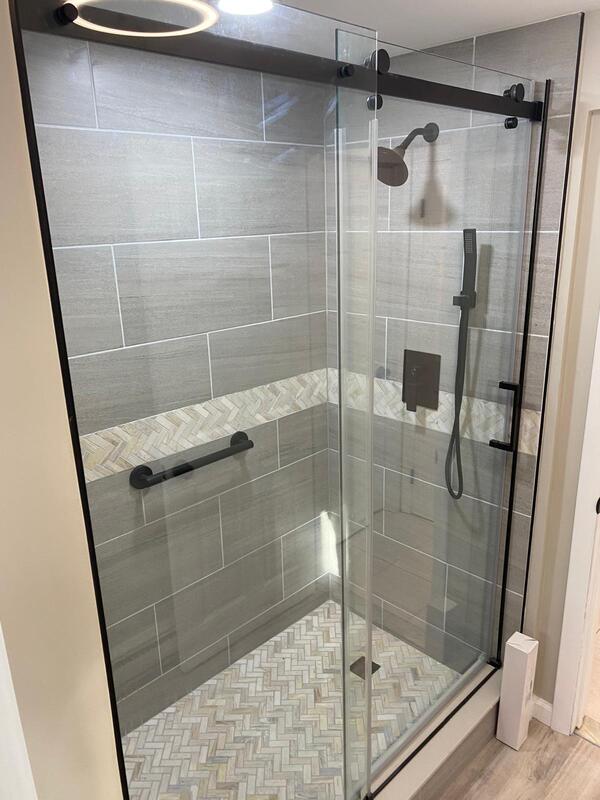 Walk-in glass shower with custom tile and matte-black fixtures