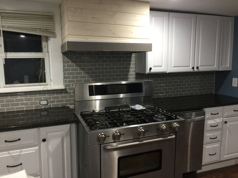 Kitchen remodel with custom wood range hood and gas range