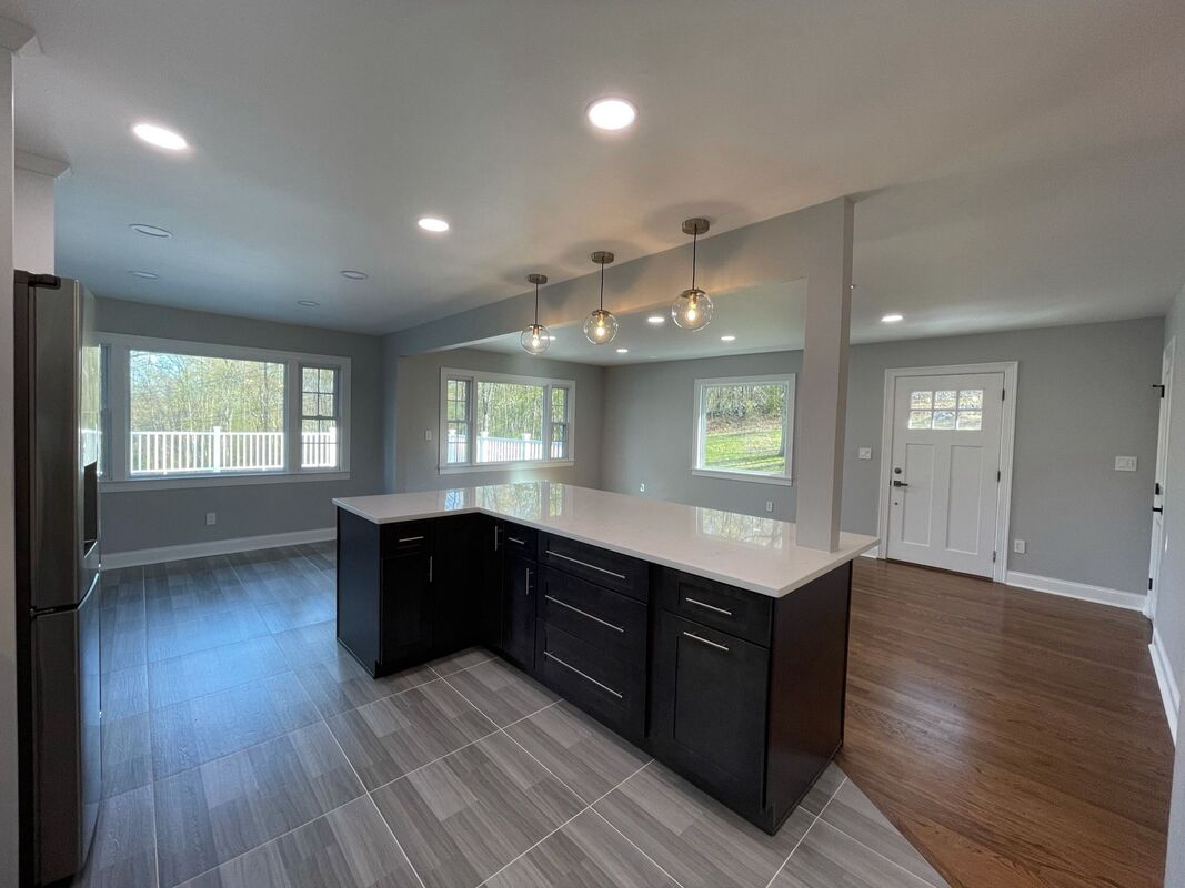 Open living area with a custom dark island and pendant lighting